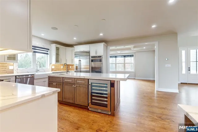 a kitchen with stainless steel appliances granite countertop a lot of counter space and wooden floors