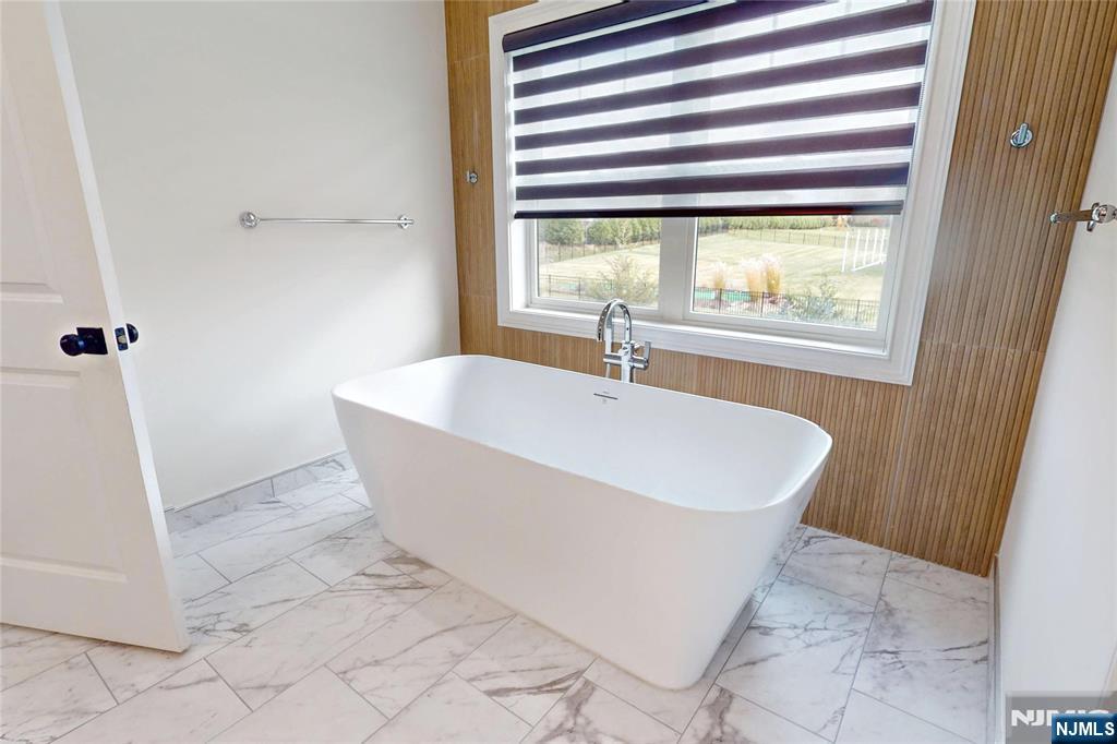 19 Meadowbrook Road Upper Saddle River, NJ 07458 - Photo 25 of 47 a white bath tub sitting in a bathroom next to a window