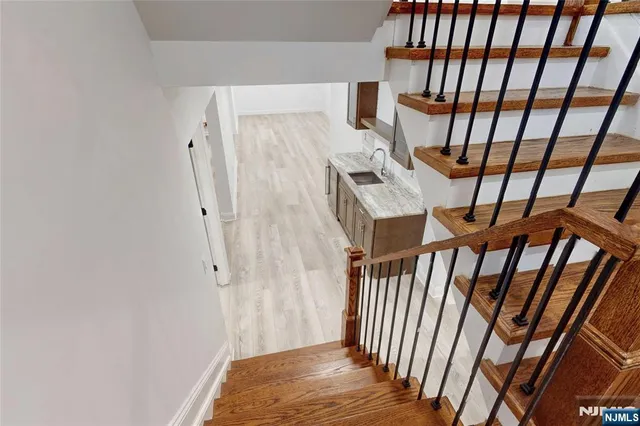 a view of an empty room with wooden floor and entrance