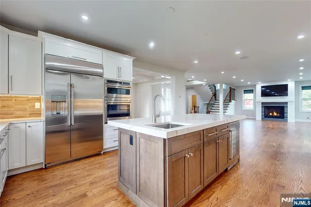 a kitchen with stainless steel appliances granite countertop a refrigerator and a stove top oven