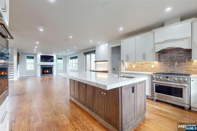 a kitchen with stainless steel appliances granite countertop a stove top oven a sink and a oven