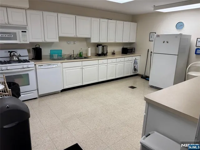 a kitchen with white cabinets and white appliances