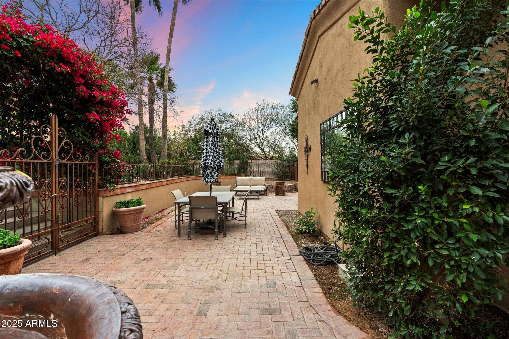 6402 East Chaparral Road Paradise Valley, AZ 85253 - Photo 56 of 125 a view of a patio with table and chairs potted plants and large tree