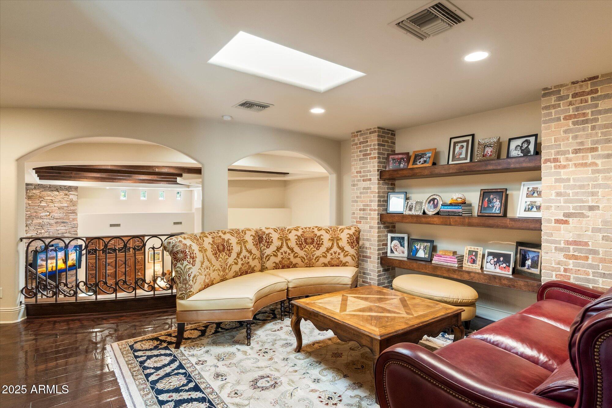6402 East Chaparral Road Paradise Valley, AZ 85253 - Photo 69 of 125 a living room with furniture and a book shelf