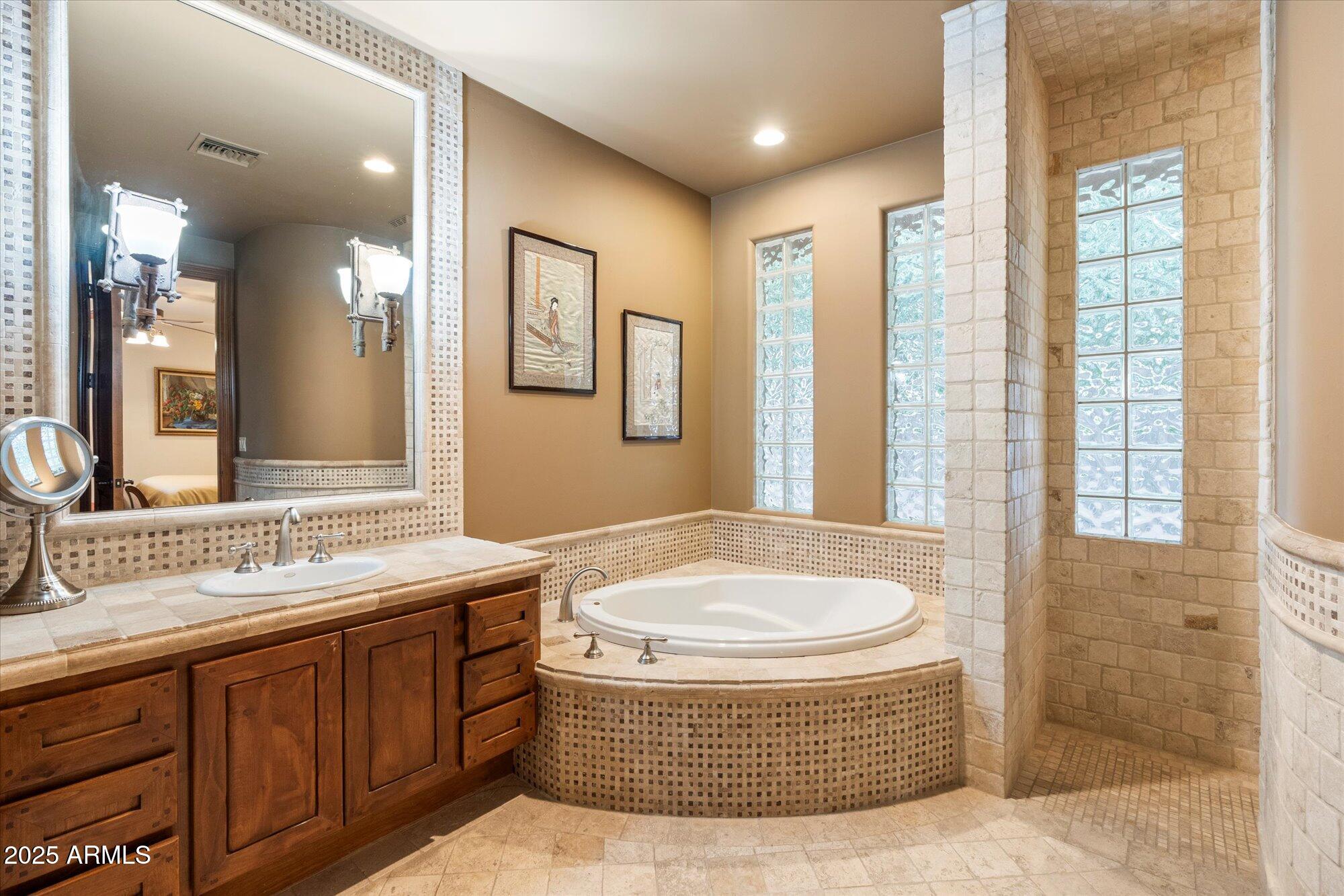 6402 East Chaparral Road Paradise Valley, AZ 85253 - Photo 80 of 125 a bathroom with a tub sink and mirror