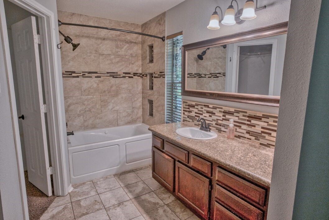 308 County Road 893B Angleton, TX 77515 - Photo 32 of 41 a bathroom with a granite countertop sink a toilet and shower