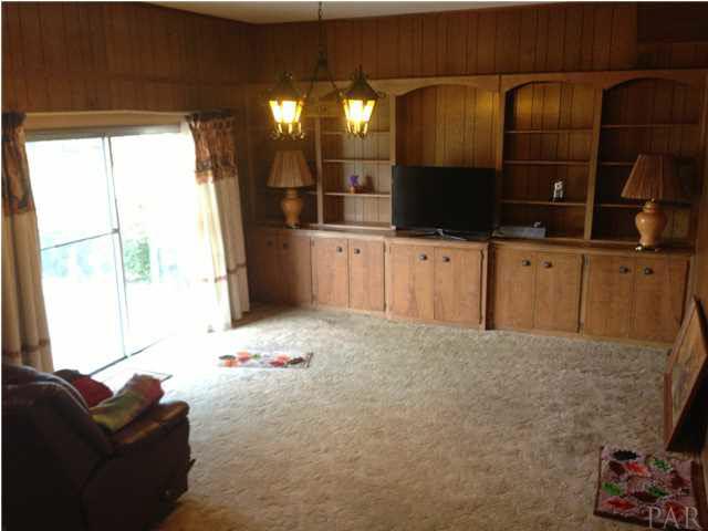 7495 Gunter Road Pensacola, FL 32526 - Photo 7 of 25 Great room with built-in entertainment area w/ shelving and cabinetry, and sliding glass door leading on the back patio.