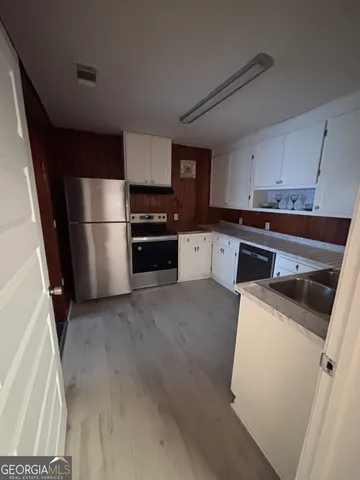 a kitchen with a refrigerator sink and stove top oven