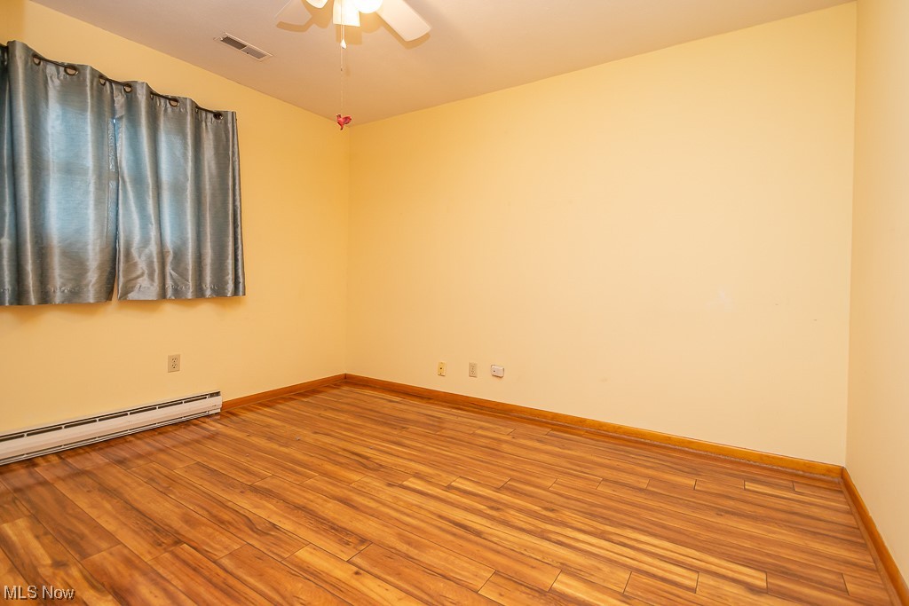 5 Pleasantview Vermilion, OH 44089 - Photo 20 of 37 Unfurnished room with baseboard heating, ceiling fan, and light hardwood / wood-style floors