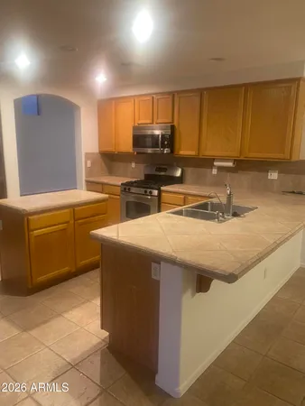a kitchen with stainless steel appliances granite countertop a sink a stove counter space and cabinets