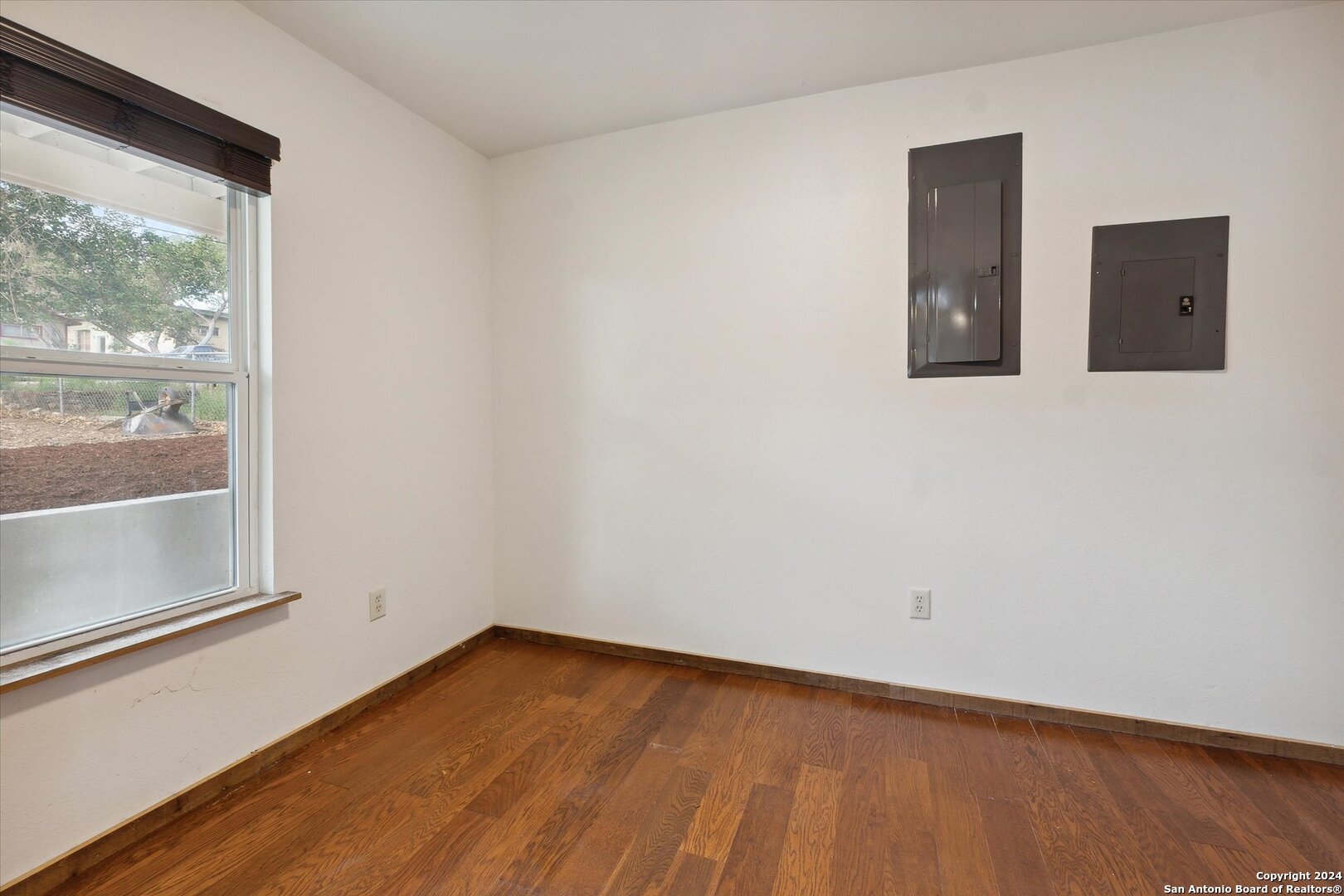 497 Black Bass Road Lakehills, TX 78063 - Photo 13 of 54 a view of an empty room with wooden floor and a window