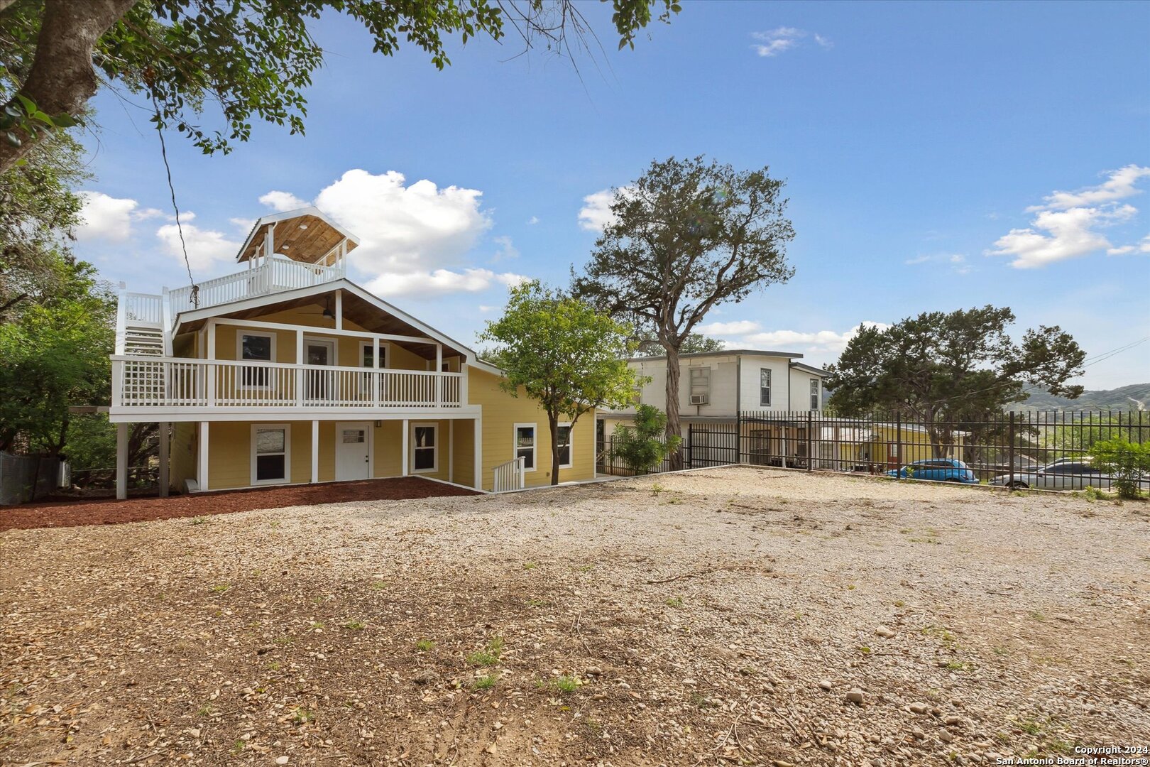 497 Black Bass Road Lakehills, TX 78063 - Photo 2 of 54 a front view of a house with a yard and trees