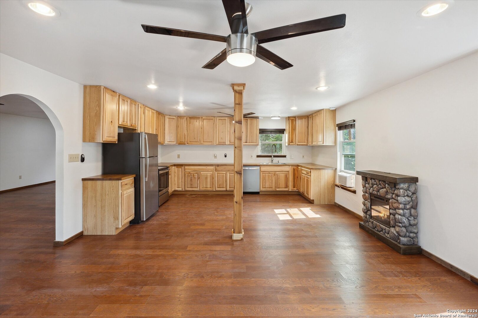 497 Black Bass Road Lakehills, TX 78063 - Photo 22 of 54 a kitchen with stainless steel appliances a refrigerator and a stove top oven