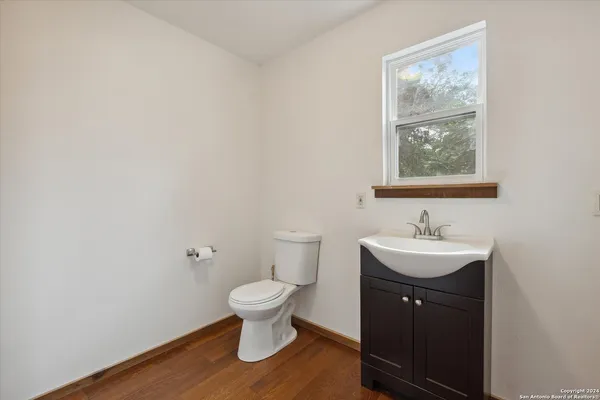 an empty room with wooden floor closet and windows