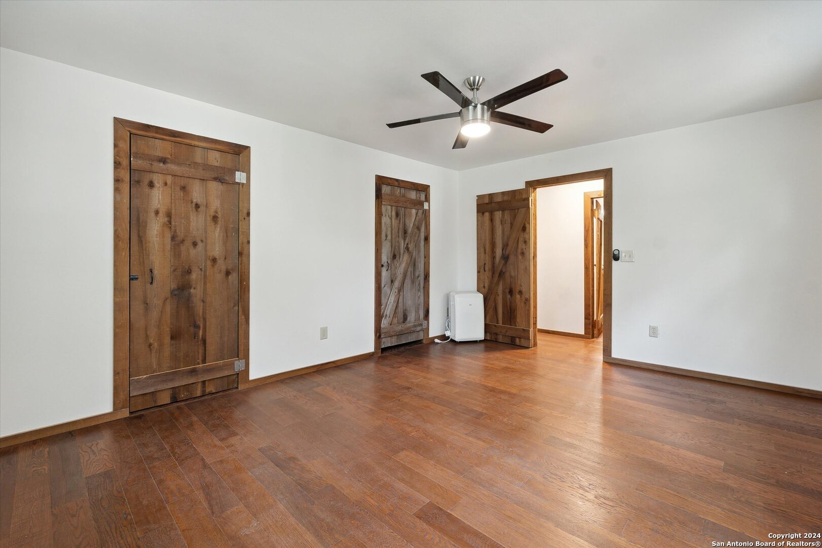497 Black Bass Road Lakehills, TX 78063 - Photo 26 of 54 an empty room with wooden floor closet and windows