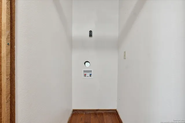 a view of a livingroom with fireplace a ceiling fan and wooden floor