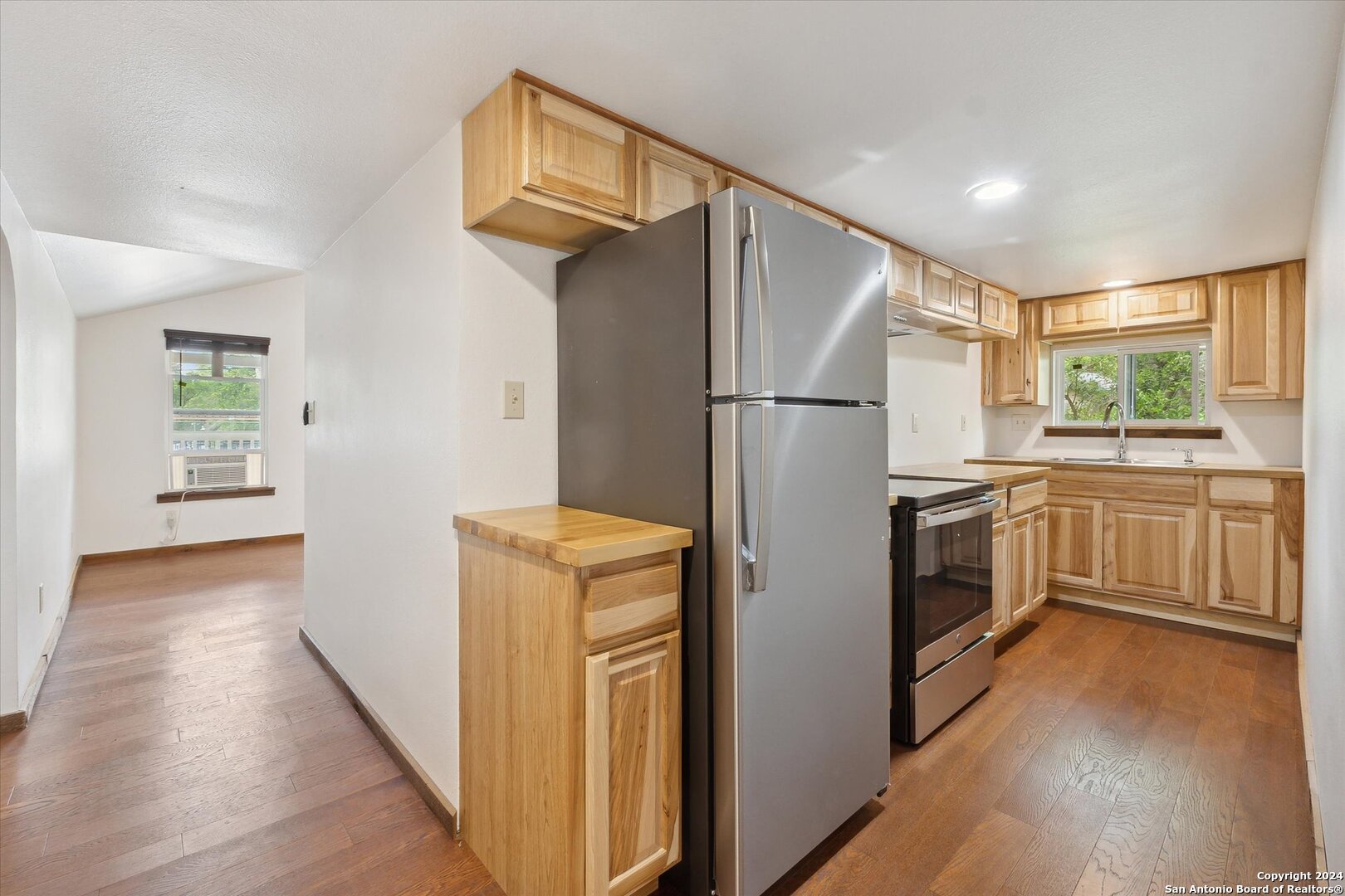 497 Black Bass Road Lakehills, TX 78063 - Photo 34 of 54 a kitchen with a refrigerator a sink and dishwasher