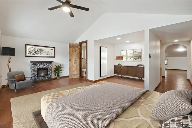 a spacious bedroom with a bed and a fireplace