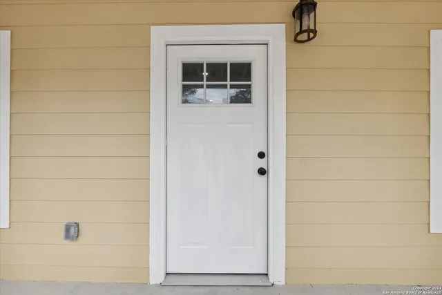 an empty room with wooden floor a ceiling fan and a fireplace