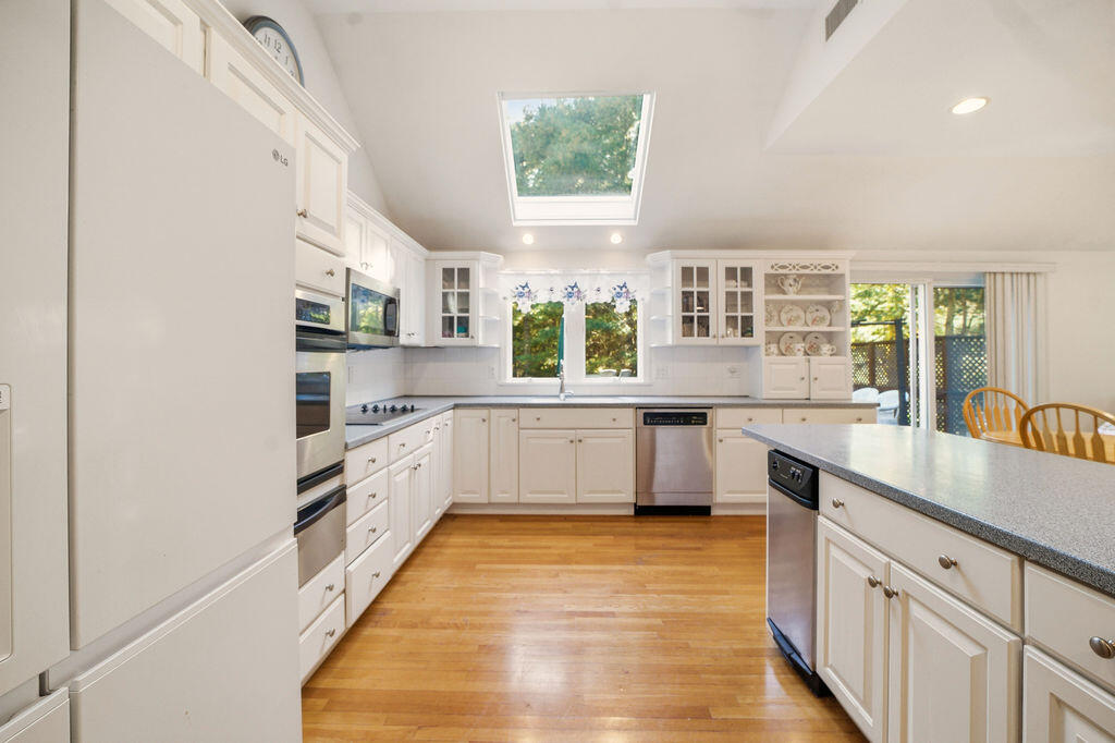 139 Falling Leaf Lane Osterville, MA 02655 - Photo 14 of 40 a white kitchen with stainless steel appliances granite countertop a stove a sink dishwasher and white cabinets with wooden floor