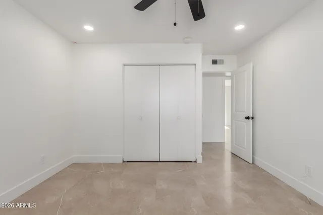 an empty room with ceiling fan and window