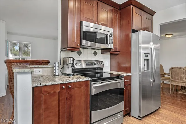 a kitchen with stainless steel appliances granite countertop a stove microwave and refrigerator