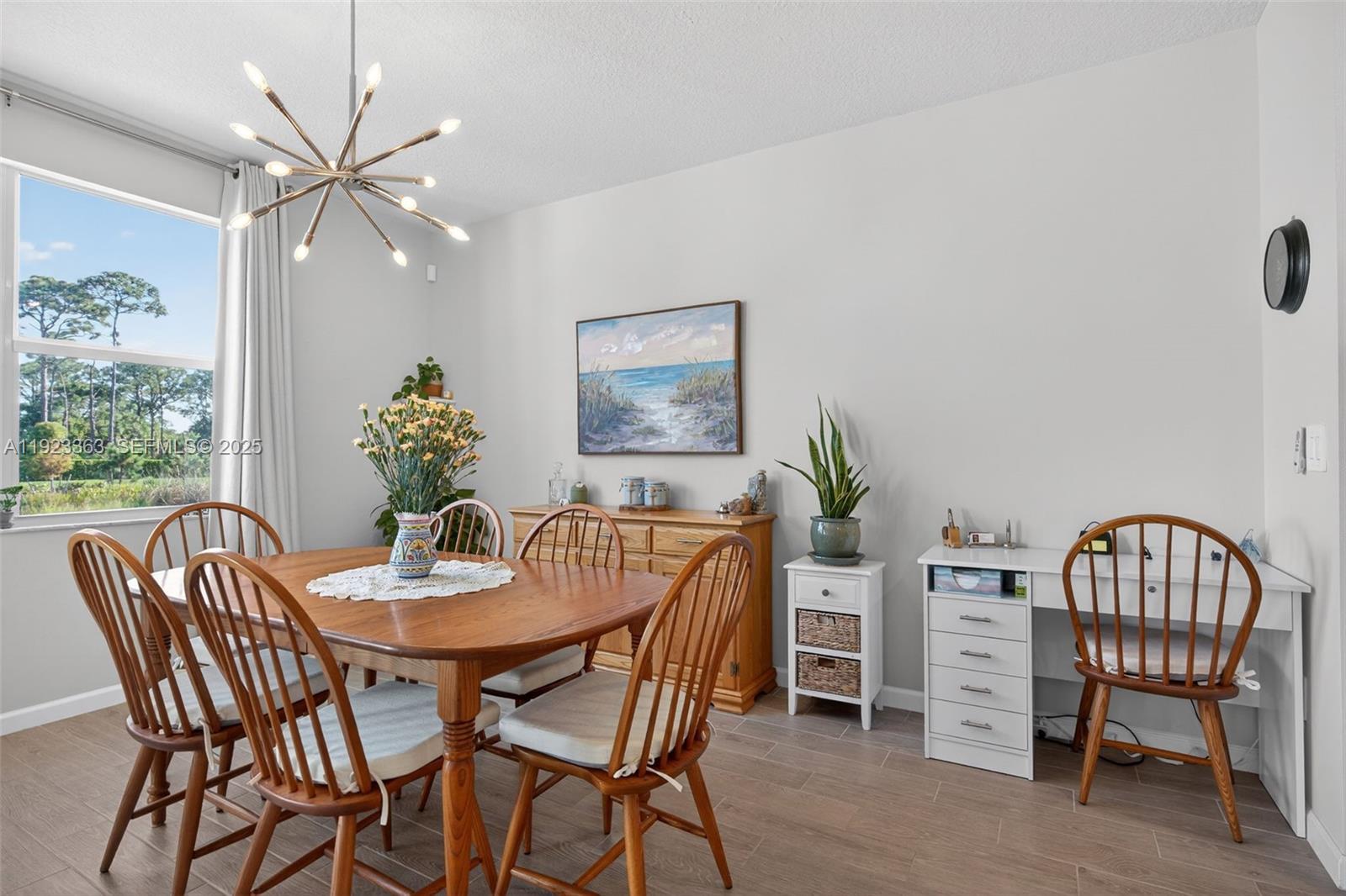 5746 Southeast Edgewater Circle Stuart, FL 34997 - Photo 11 of 38 a dining room with furniture a potted plant and a chandelier fan