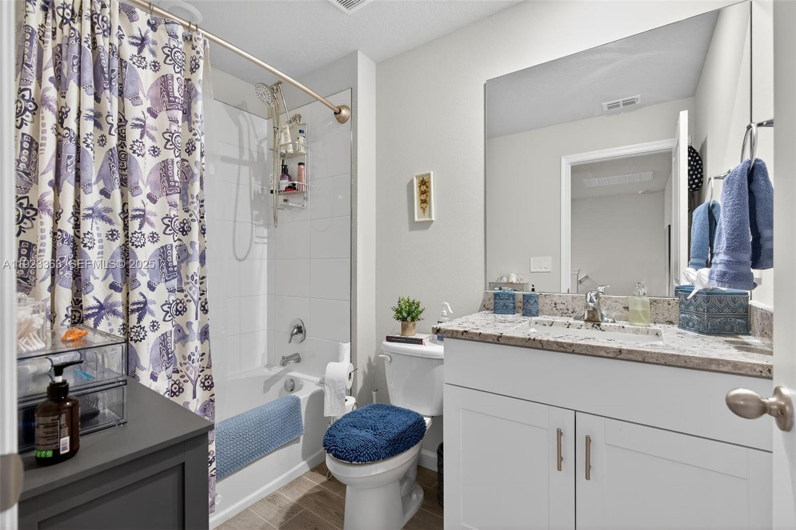 5746 Southeast Edgewater Circle Stuart, FL 34997 - Photo 20 of 38 a bathroom with a granite countertop sink a toilet and a mirror