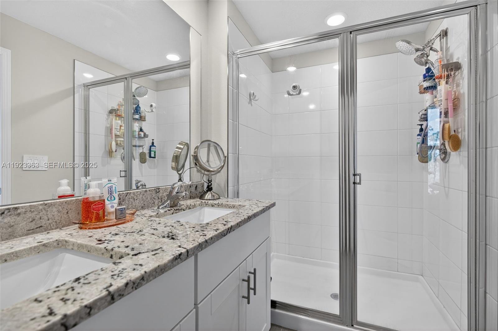 5746 Southeast Edgewater Circle Stuart, FL 34997 - Photo 25 of 38 a bathroom with a granite countertop sink and a mirror