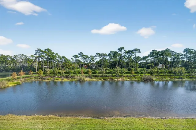 a view of a lake with a large building and trees in the background
