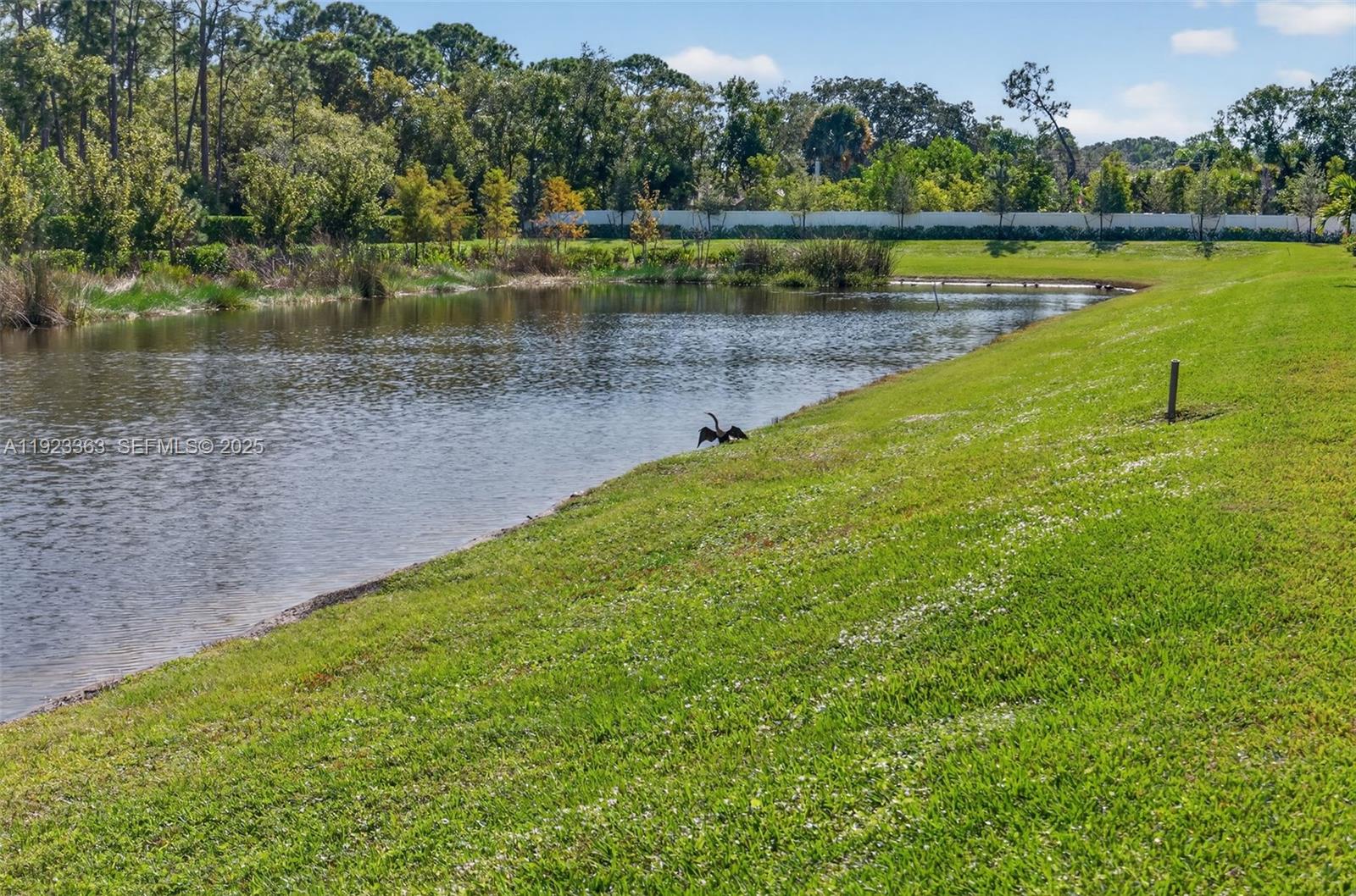 5746 Southeast Edgewater Circle Stuart, FL 34997 - Photo 36 of 38 a view of a lake with a large building and trees in the background