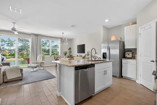 a kitchen with stainless steel appliances granite countertop a sink stove and cabinets