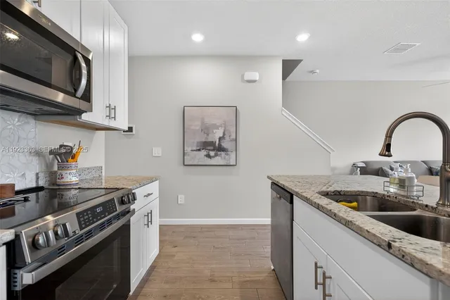a kitchen with sink a microwave and cabinets