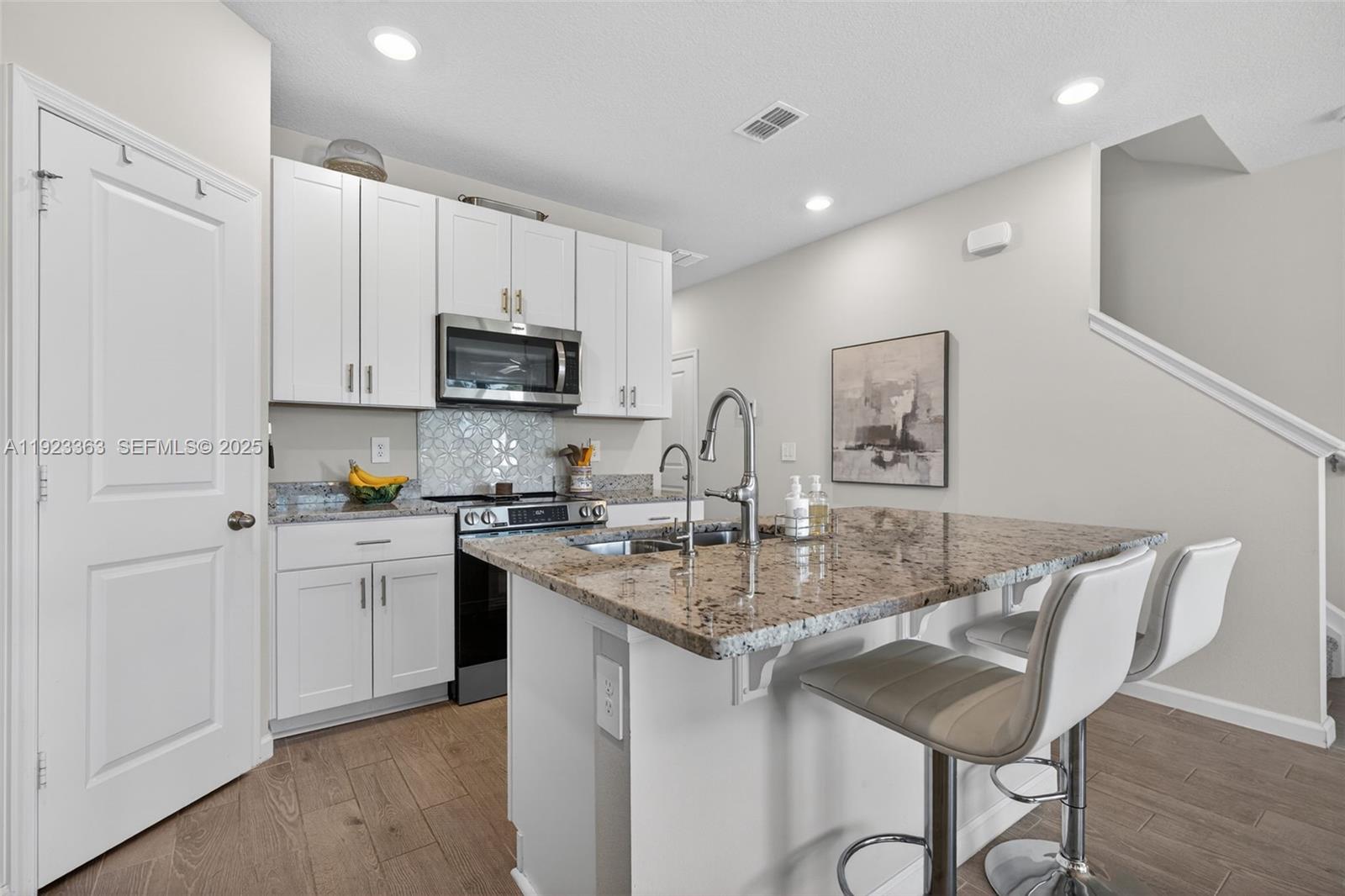 5746 Southeast Edgewater Circle Stuart, FL 34997 - Photo 9 of 38 a kitchen with sink a microwave and cabinets