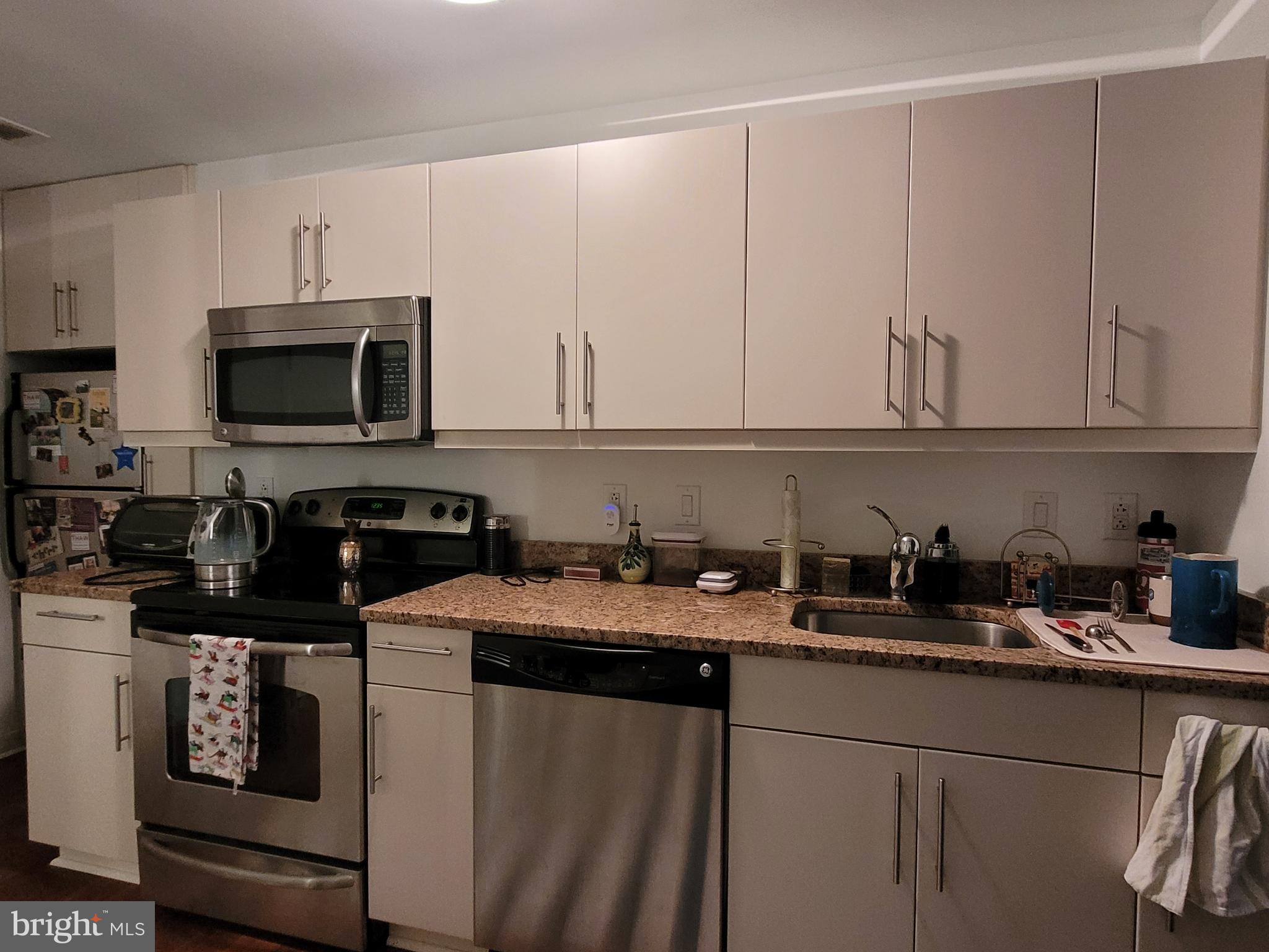 219-29 South 18th Street, Unit 405A Philadelphia, PA 19103 - Photo 6 of 19 a kitchen with stainless steel appliances granite countertop a sink a stove a microwave and cabinets