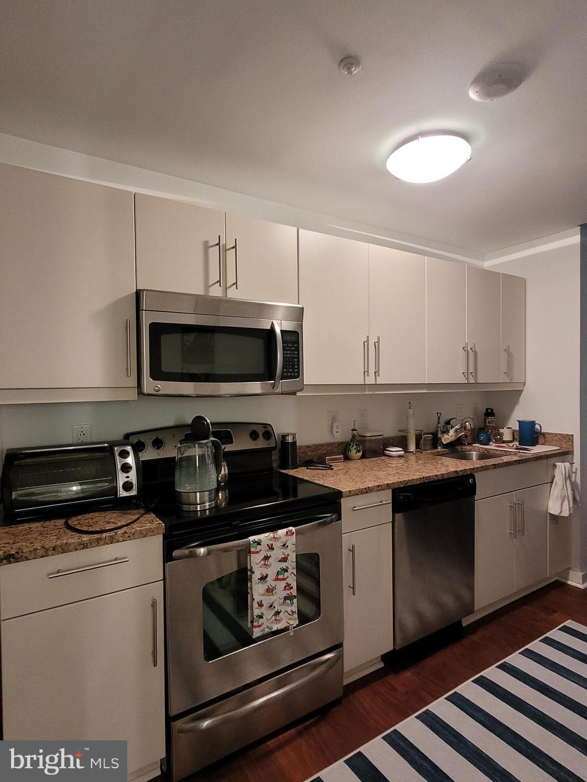 219-29 South 18th Street, Unit 405A Philadelphia, PA 19103 - Photo 7 of 19 a kitchen with stainless steel appliances a stove and a microwave