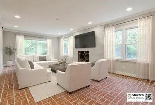a living room with furniture a flat screen tv and a fireplace