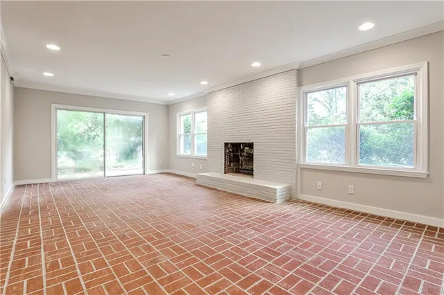a view of an empty room with a window and a fireplace
