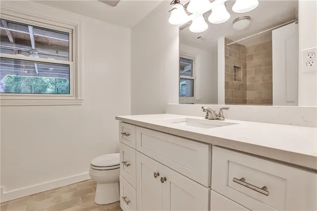 a bathroom with a toilet a sink and mirror
