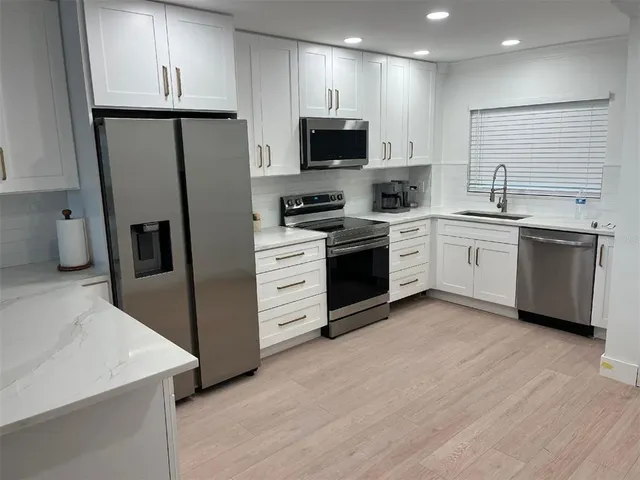 a kitchen with stainless steel appliances a refrigerator stove and microwave