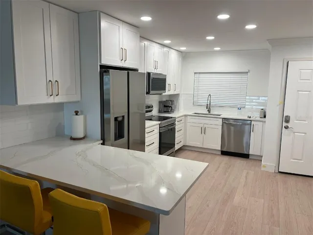 a kitchen with stainless steel appliances a refrigerator sink and cabinets
