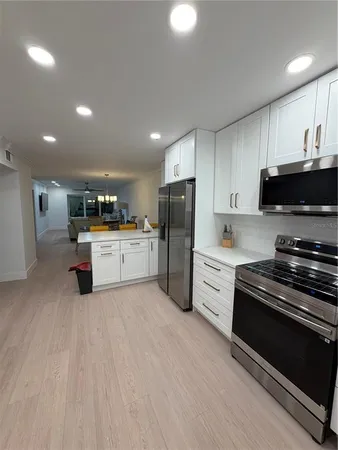 a kitchen with stainless steel appliances and white cabinets