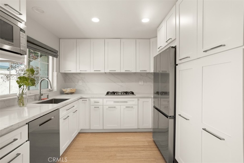 32 Columbia Irvine, CA 92612 - Photo 11 of 34 a kitchen with stainless steel appliances granite countertop a sink a stove and a refrigerator
