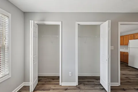 a view of a hallway with wooden floor and closet area