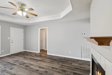 a view of a livingroom with wooden floor and a ceiling fan