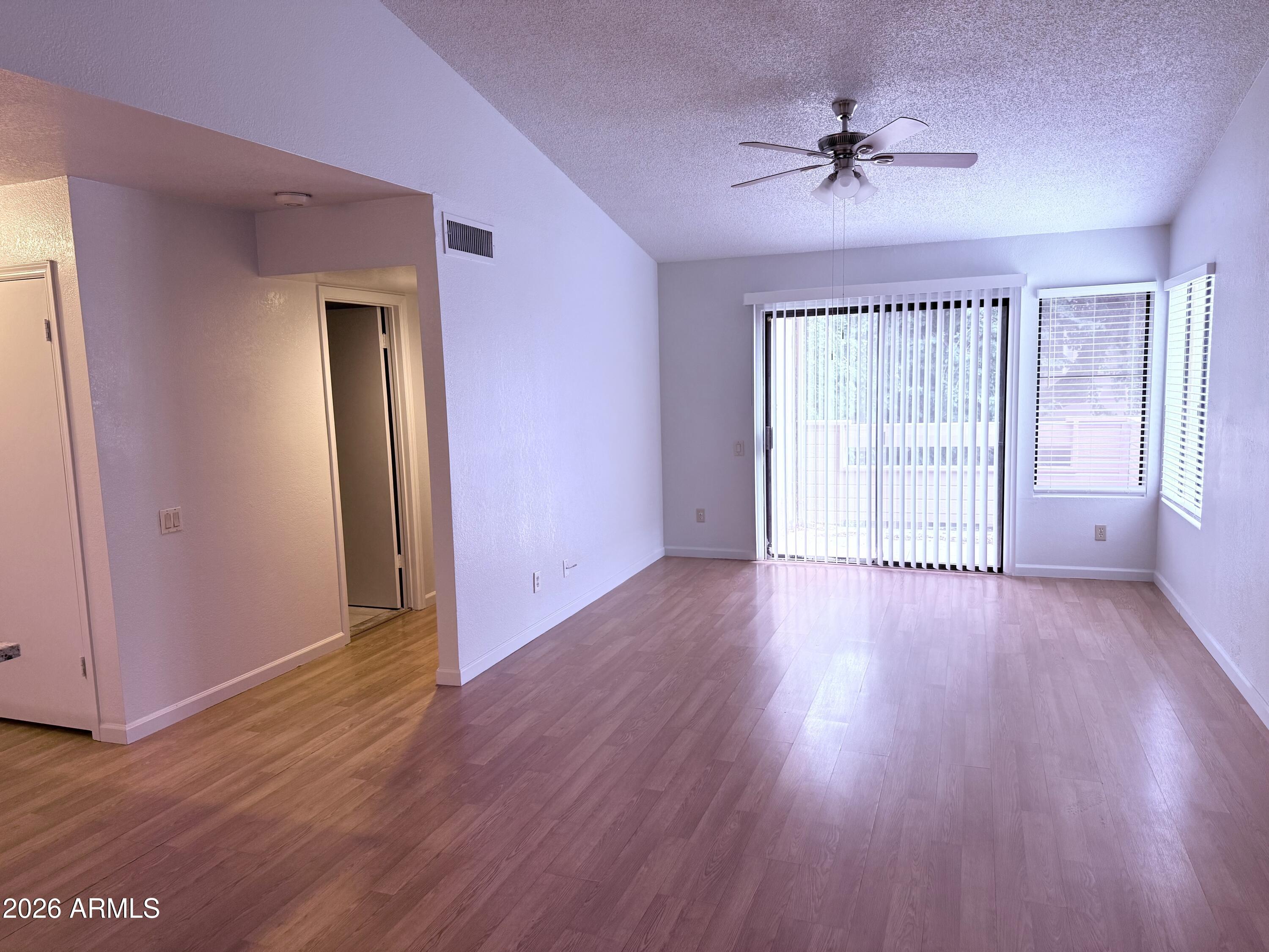 2035 South Elm Street, Unit 208 Tempe, AZ 85282 - Photo 5 of 6 a view of an empty room with wooden floor and a window