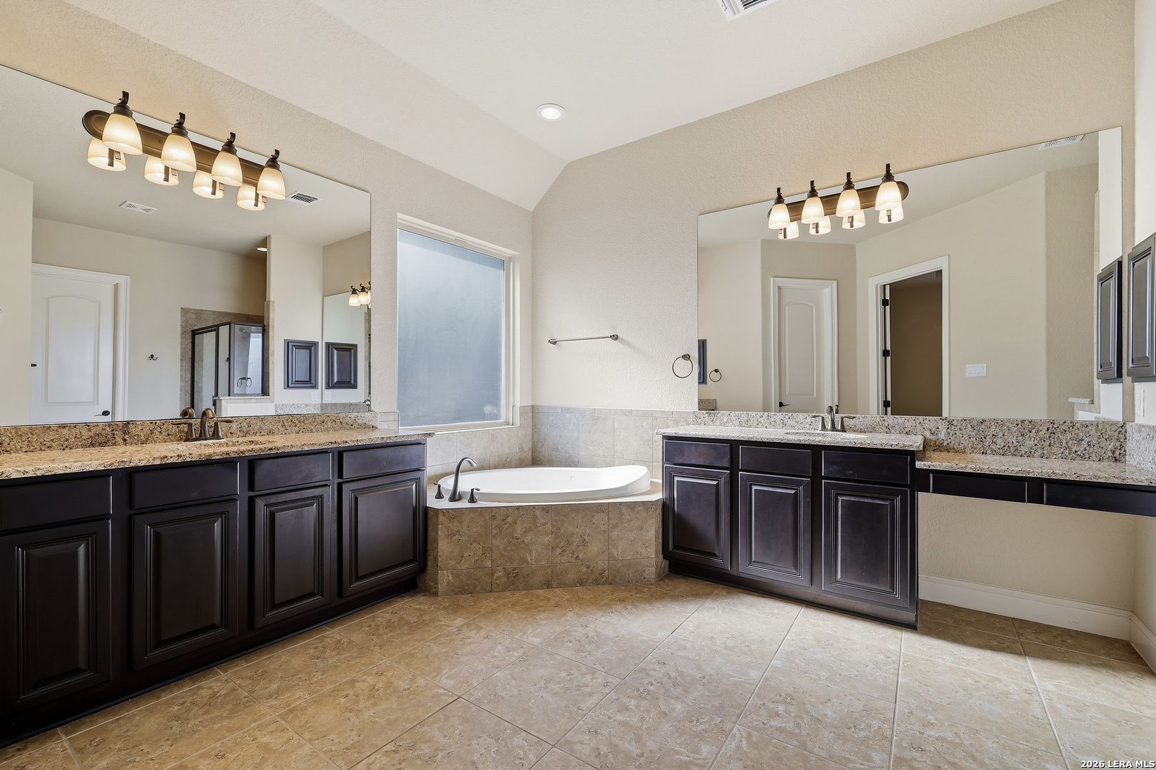 19414 Arrowood Place Garden Ridge, TX 78266 - Photo 15 of 25 a spacious bathroom with a granite countertop double vanity sink a bathtub and a mirror