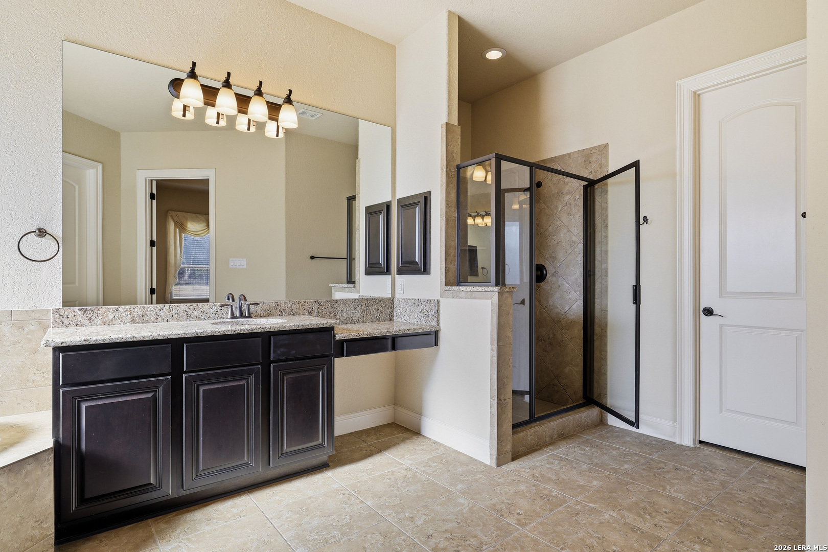 19414 Arrowood Place Garden Ridge, TX 78266 - Photo 16 of 25 a spacious bathroom with a granite countertop sink a mirror and a shower