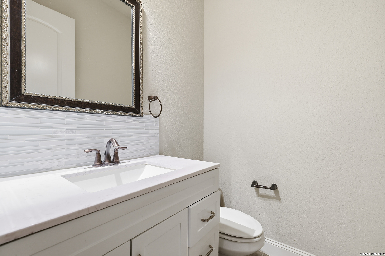 19414 Arrowood Place Garden Ridge, TX 78266 - Photo 18 of 25 a bathroom with a sink a toilet and mirror