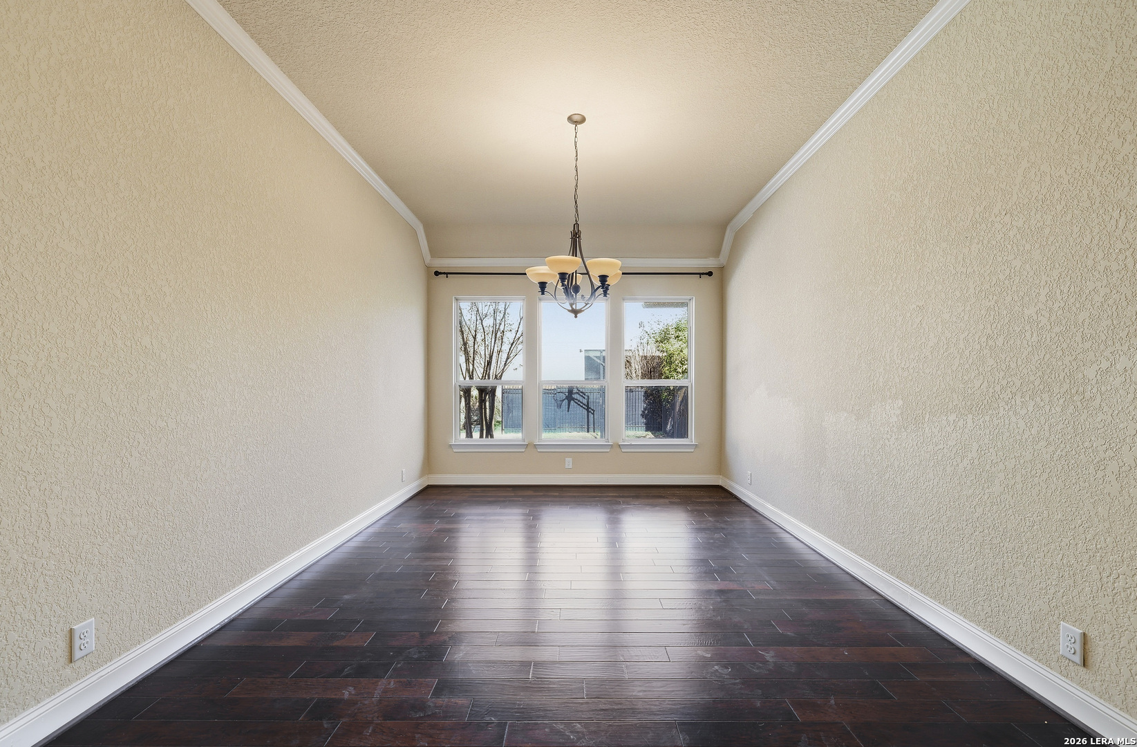 19414 Arrowood Place Garden Ridge, TX 78266 - Photo 8 of 25 an empty room with wooden floor chandelier and window